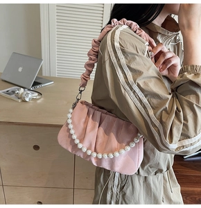Détail du sac nuage plissé rose avec poignée en perles et bandoulière en satin