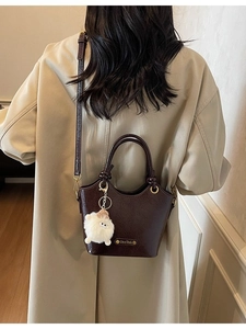 Retro dark brown glossy leather bucket bag with top handles and plush lamb charm