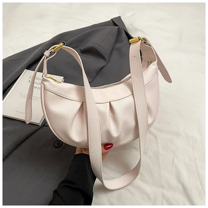 Détail du sac croissant rose clair avec cuir de lychee plissé et garnitures dorées