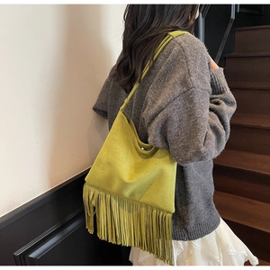 Dettaglio della borsa a tracolla bohémien con frange verde senape e trama in pelle scamosciata