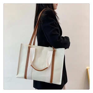 Détail d'un grand sac fourre-tout en toile avec lanières en cuir marron et boucles en métal