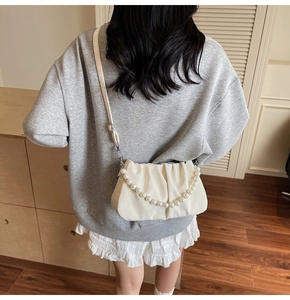 Détail du sac nuage plissé blanc avec chaîne de perles et bandoulière en cuir réglable
