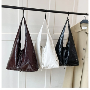 Detailed view of large tote bags in black white and brown with glossy crinkled texture