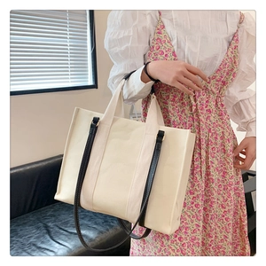 Détail du sac cabas en toile avec bandoulières en cuir noir et grande contenance