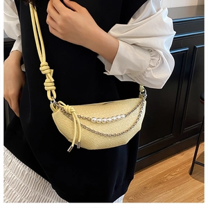 Détail du sac demi-lune jaune clair avec texture crocodile et décor de perles