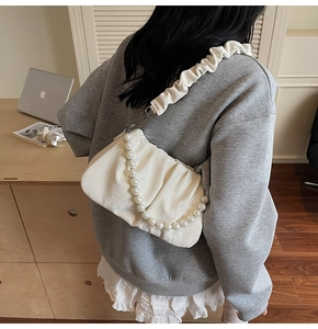 Détail du sac nuage plissé blanc avec chaîne de perles et bandoulière en tissu froncé