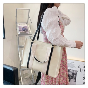 Grand sac fourre-tout en toile beige avec sangles contrastées et magazine