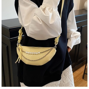 Détail du sac demi-lune jaune à motif crocodile avec perles et bandoulière en chaîne
