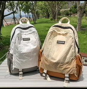 Close-up of two large capacity waterproof outdoor backpacks in beige and white gray colors