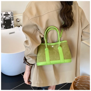 Detail of green tote bag with suede texture and metal rivet on a minimalist background