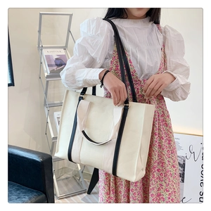 Sac fourre-tout tendance en toile avec anses noires dans un cadre lifestyle chic