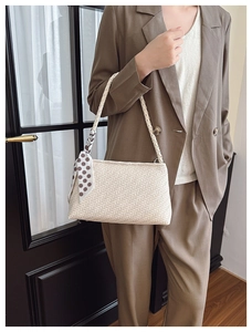 Detail of cream woven handbag with V-shaped texture and vintage polka dot silk scarf