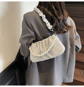 Détail du sac plissé en satin gris clair avec bandoulière perle et boucle argentée