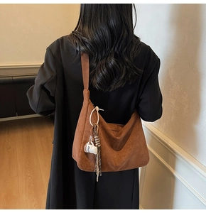 Brown suede slouchy hobo bag featuring a cute coffee cup charm and woven fringe tassel