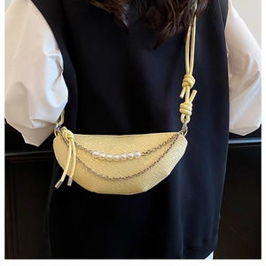 Détail d'un sac demi-lune jaune avec doubles chaînes métalliques et perles déco