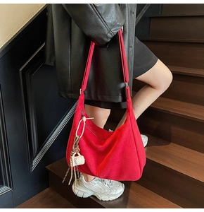 Detail of red oversized tote bag with adjustable strap and decorative coffee cup charm