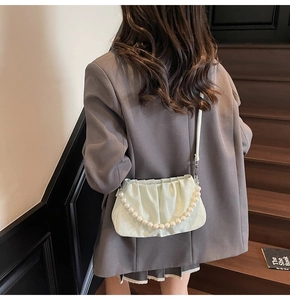 Détail du sac nuage vert menthe avec chaîne décorative en perles et bandoulière en cuir