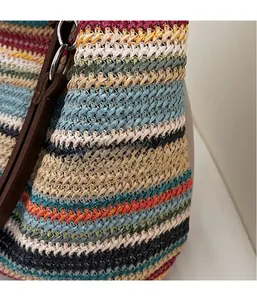 Dettaglio macro della borsa a righe colorate con trama 3D e manico in pelle