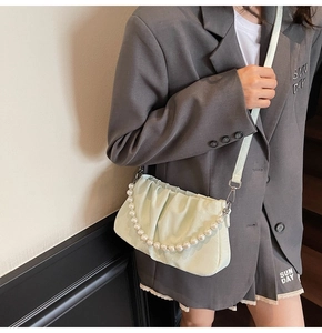 Détail du sac nuage vert menthe avec poignée en perles et bandoulière en cuir souple