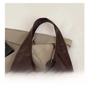 Macro detail of glossy dark brown tote bag with wide comfortable shoulder strap