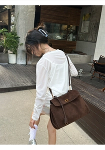 Nahaufnahme der dunkelbraunen Wildledertasche mit Vintage-Metallschnalle und matter Textur
