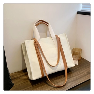 Détail du sac fourre-tout en toile avec doubles poignées et bandoulières en cuir marron