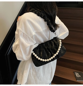 Détail du sac nuage plissé noir avec chaîne en perles et bandoulière élégante