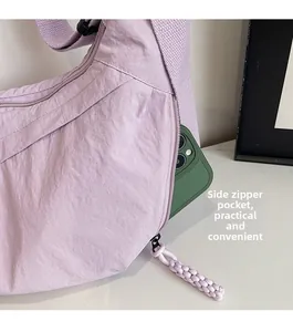 Dettaglio della tasca laterale con cerniera di una borsa a tracolla viola con smartphone