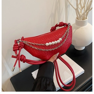 Détail du sac demi-lune tissé rouge avec chaîne en perles et sangle nouée