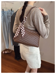 Detailed close-up of dark brown woven texture shoulder bag with decorative silk scarf