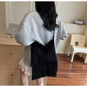 Detalle del bolso bandolera negro con flecos y atuendo casual de verano