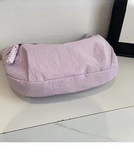 Dettaglio della borsa a mezzaluna in nylon lavanda con tessuto plissettato e corda