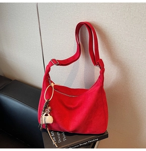Macro shot of red crescent tote bag detail with COFFEE charm and silver buckle strap