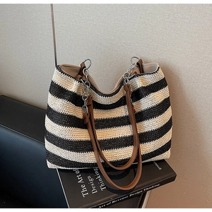 Dettaglio della borsa tote intrecciata a righe con tracolla in PU marrone e catena in metallo