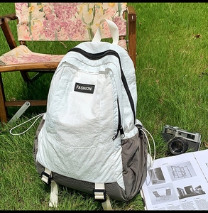 Detail of lightweight outdoor backpack with nylon texture, fashion patch, and side buckle