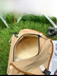Internal capacity of khaki crossbody bag showing space for camera and magazine