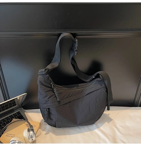 Dettaglio della borsa a tracolla a mezzaluna in nylon nero con cinturino regolabile e fibbia
