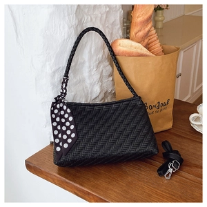 Detail of woven black shoulder bag with polka dot scarf and detachable long strap
