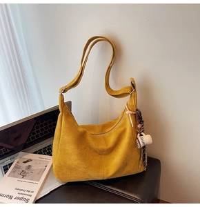 Detail of ginger suede hobo bag with adjustable strap and coffee cup charm decoration