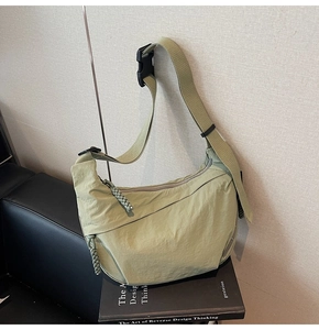 Dettaglio borsa a tracolla a mezzaluna in nylon verde chiaro con tirazip intrecciato