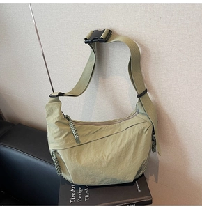 Dettaglio borsa a mezzaluna in nylon verde chiaro con tracolla e fibbia in plastica