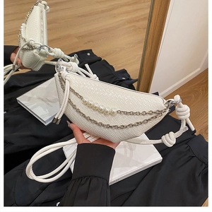 Détail du sac demi-lune blanc avec texture crocodile, perles et poignée en nœud tressé