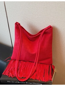 Borsa a tracolla vintage in pelle scamosciata rossa con frange su sfondo minimalista