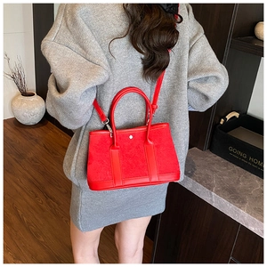 Detail of red suede and leather tote bag with gold ring buckle and shoulder strap