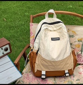 Detailed close-up of a three-color panelled outdoor backpack in earth tones on a camping chair