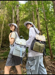 Close-up of lightweight nylon outdoor backpacks in blue and black colors in a forest