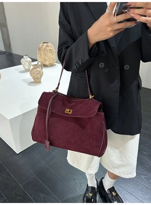 Detailaufnahme der weinroten Wildledertasche mit goldenem quadratischem Drehverschluss