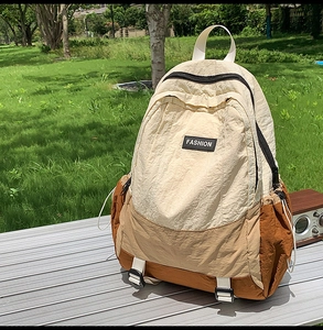 Detail of color-block nylon backpack with FASHION label on an outdoor metal table