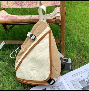 Outdoor crossbody bag with khaki contrast design and fashion label on natural grass