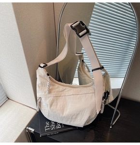 Dettaglio della borsa dumpling bianco sporco con tracolla regolabile riflessa nello specchio